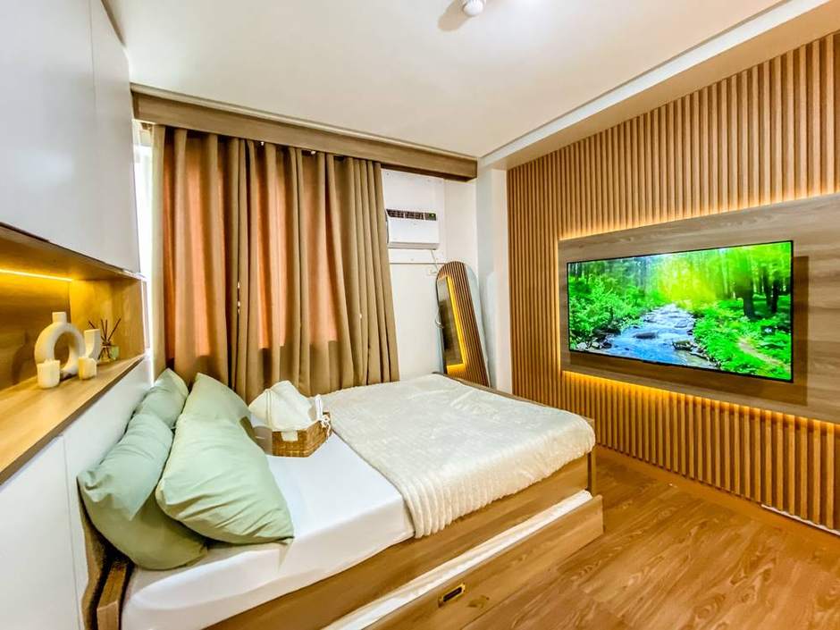 Bed platform with a lit timber headboard niche and a recessed TV panel